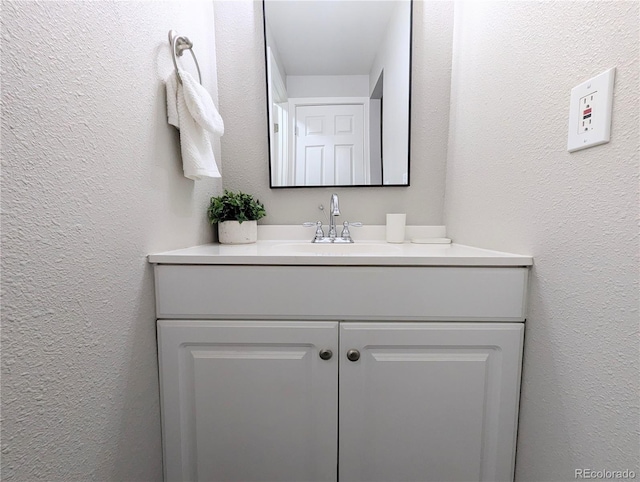 bathroom featuring vanity and a textured wall