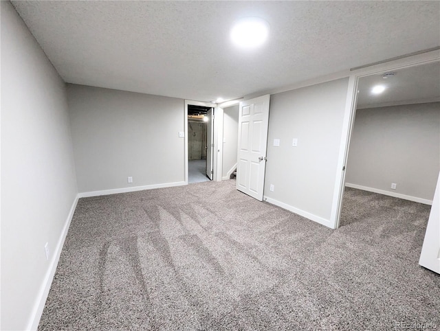 interior space featuring a textured ceiling, baseboards, and carpet floors