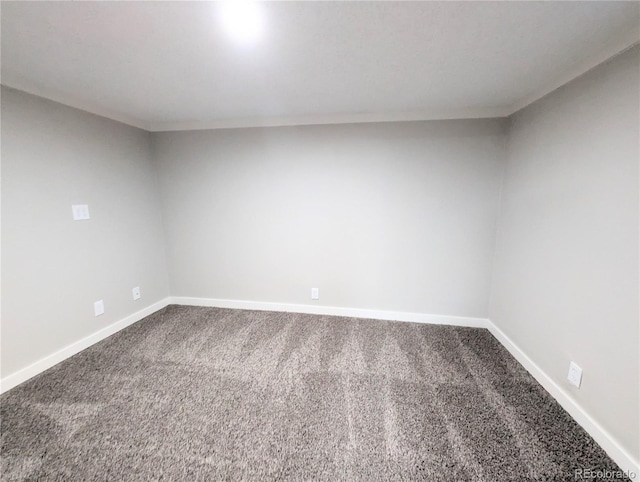 carpeted empty room featuring baseboards