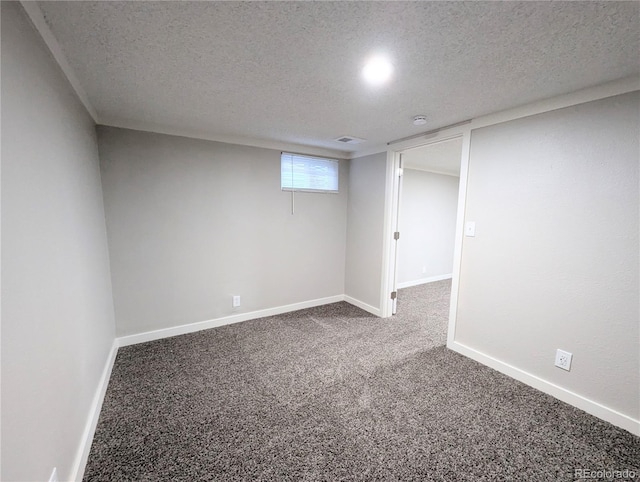 basement featuring carpet flooring, baseboards, and a textured ceiling