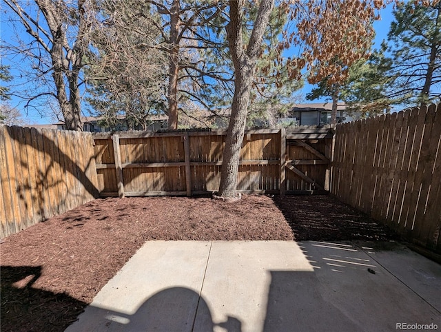 view of yard featuring a patio area, a gate, and fence