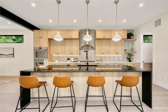 1601 S Columbine St, Denver, CO 80210 - kitchen featuring light brown cabinetry, stainless steel appliances, tasteful backsplash, a kitchen bar, and baseboards
