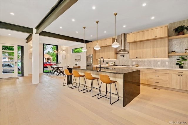 1601 S Columbine St, Denver, CO 80210 - kitchen featuring light brown cabinets, wall chimney range hood, modern cabinets, a sink, and a breakfast bar