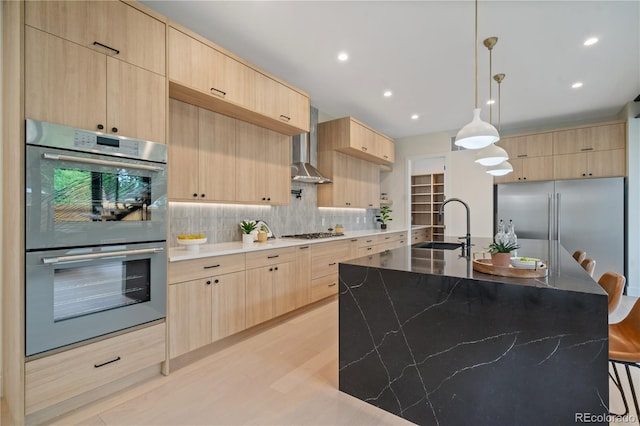 1601 S Columbine St, Denver, CO 80210 - kitchen featuring appliances with stainless steel finishes, light brown cabinetry, wall chimney range hood, a sink, and decorative backsplash