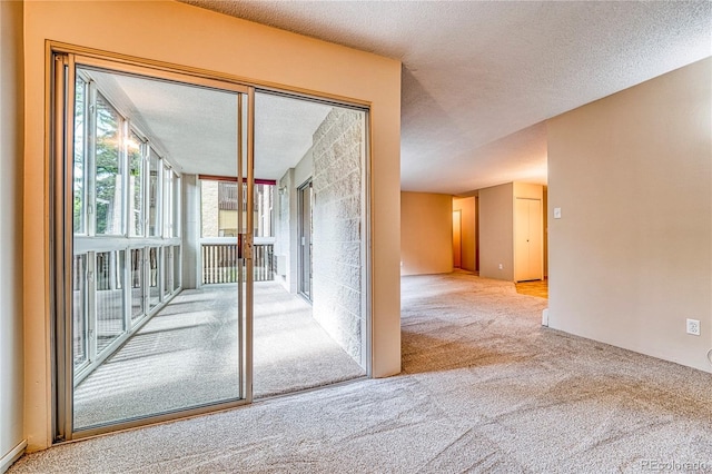 carpeted empty room featuring a textured ceiling