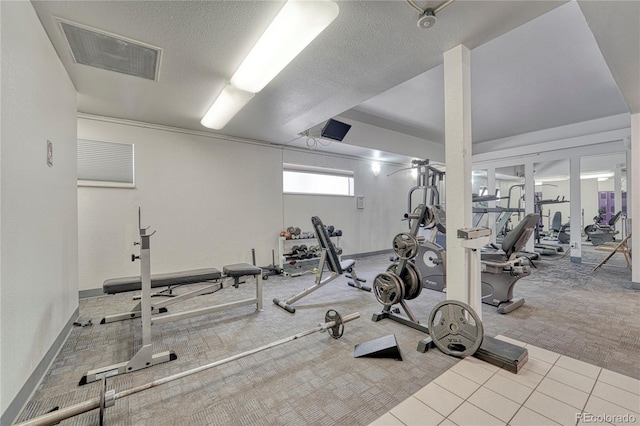 workout area featuring light colored carpet and a textured ceiling