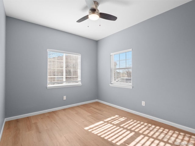 unfurnished room featuring baseboards, wood finished floors, and a ceiling fan