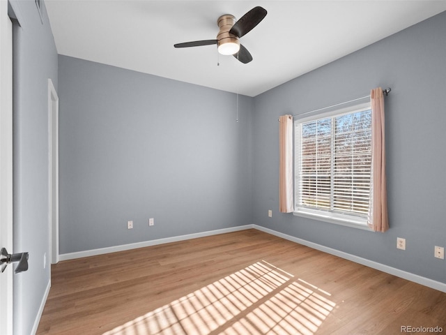 spare room with a ceiling fan, baseboards, and wood finished floors