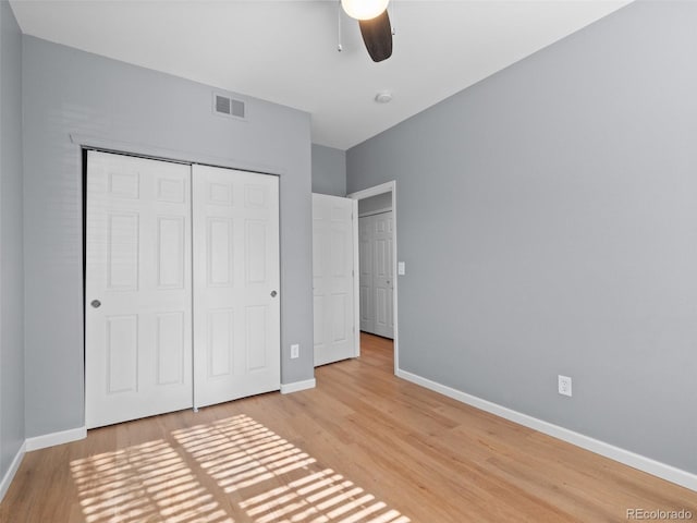 unfurnished bedroom featuring baseboards, visible vents, ceiling fan, a closet, and light wood-type flooring