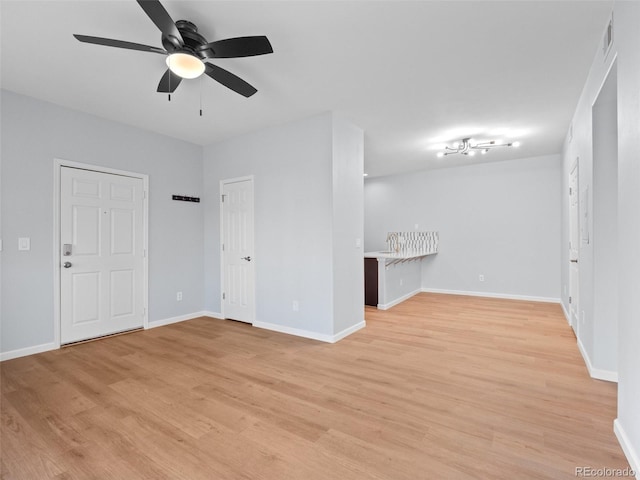 unfurnished living room with light wood-style flooring, baseboards, and ceiling fan