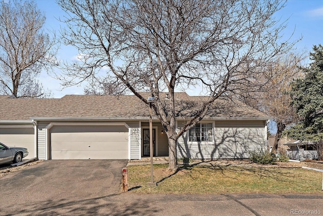 ranch-style home featuring a garage, driveway, and a shingled roof