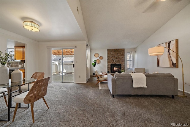 living room featuring baseboards, lofted ceiling, carpet, and a stone fireplace