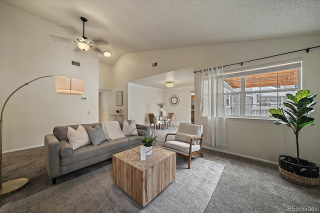 living room with visible vents, a textured ceiling, dark carpet, ceiling fan, and vaulted ceiling