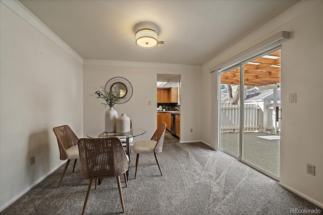 unfurnished dining area featuring crown molding, carpet flooring, and baseboards