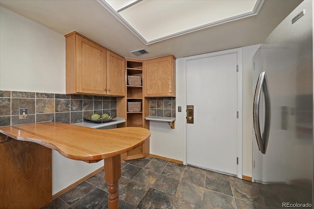 kitchen with tasteful backsplash, visible vents, baseboards, freestanding refrigerator, and open shelves