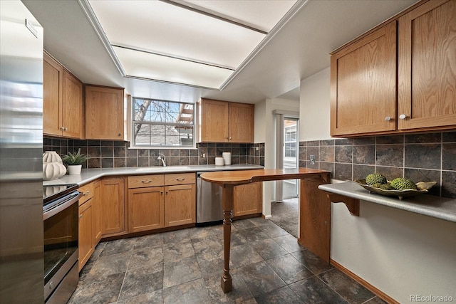 kitchen featuring plenty of natural light, backsplash, stainless steel appliances, and a sink