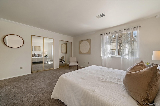 carpeted bedroom with crown molding, visible vents, multiple closets, and baseboards