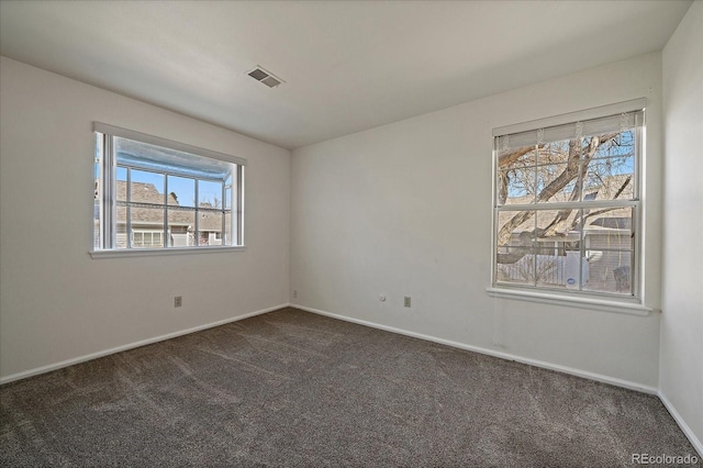 carpeted empty room featuring visible vents and baseboards