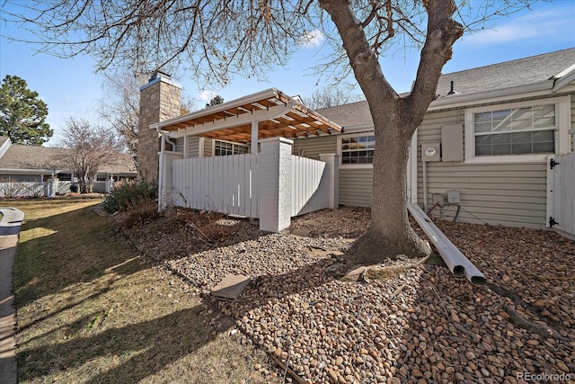 view of property exterior featuring a chimney and fence