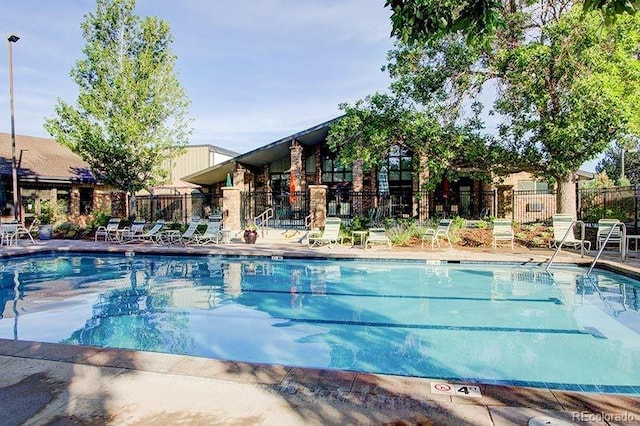 community pool featuring a patio area and fence