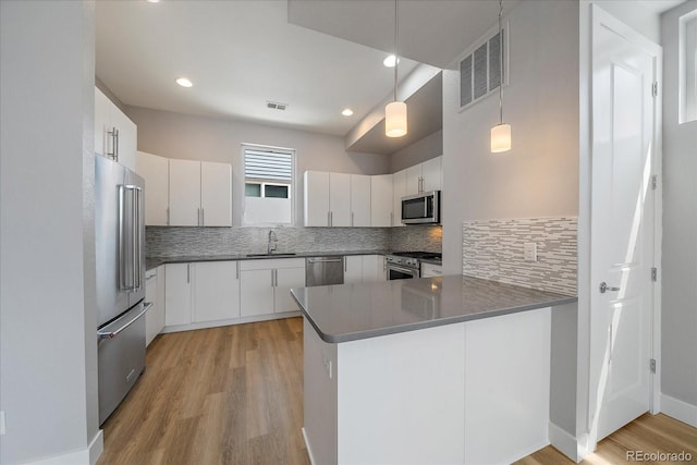 1632 Lowell Blvd Unit 5, Denver, CO 80204 - kitchen featuring high end appliances, a peninsula, light wood finished floors, tasteful backsplash, and recessed lighting