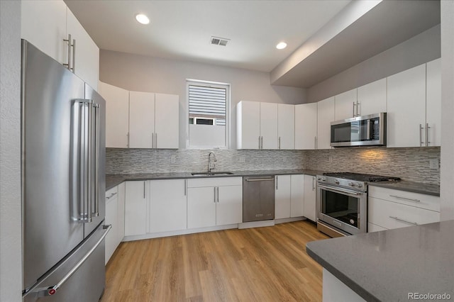 1632 Lowell Blvd Unit 5, Denver, CO 80204 - kitchen with premium appliances, dark countertops, backsplash, and recessed lighting