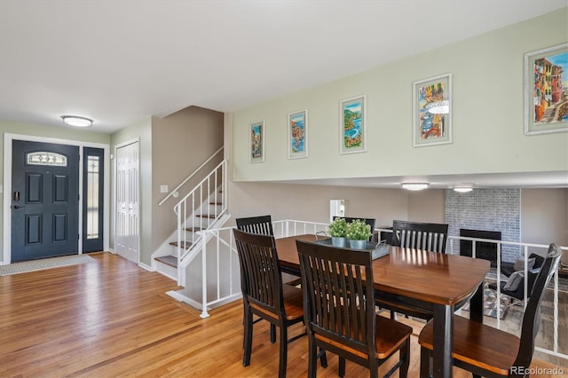 3406 E Fair Pl, Centennial, CO 80121 - dining space featuring light wood finished floors, stairway, and a brick fireplace