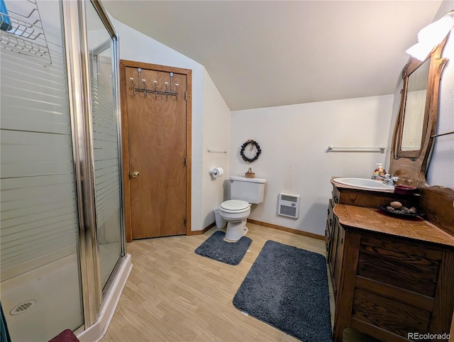 bathroom with heating unit, hardwood / wood-style floors, vaulted ceiling, vanity, and a shower with shower door