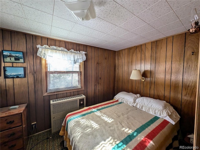 bedroom featuring wooden walls and heating unit