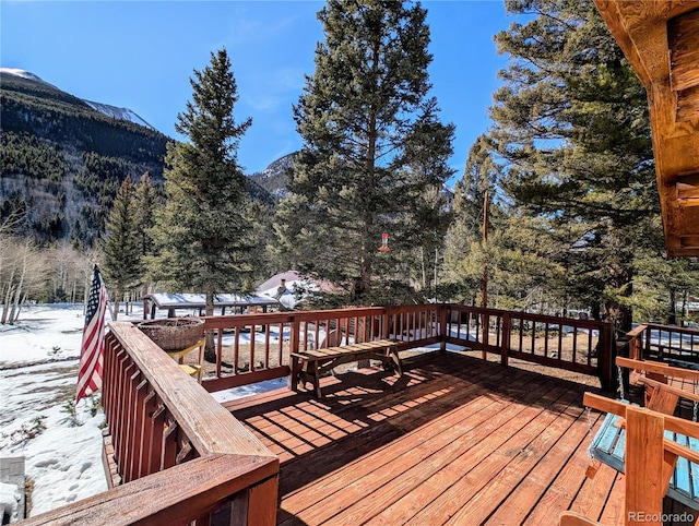 snow covered deck with a mountain view