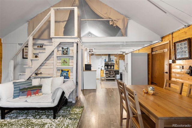 living room featuring wooden walls, hardwood / wood-style floors, and vaulted ceiling