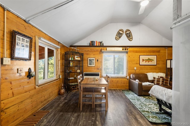 interior space with dark wood-type flooring, wooden walls, vaulted ceiling, and ceiling fan