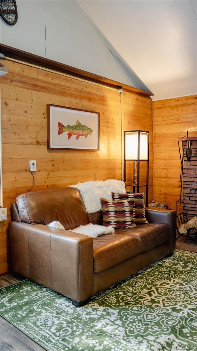 living room with wooden walls, lofted ceiling, and wood-type flooring