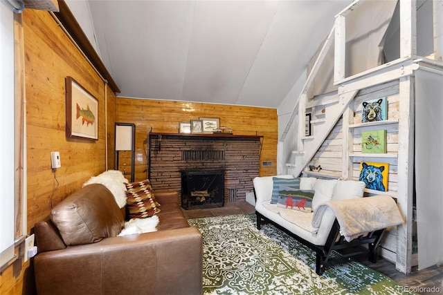 living room featuring wood walls, a fireplace, and lofted ceiling