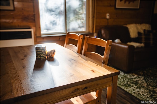 dining space featuring dark hardwood / wood-style flooring and wood walls