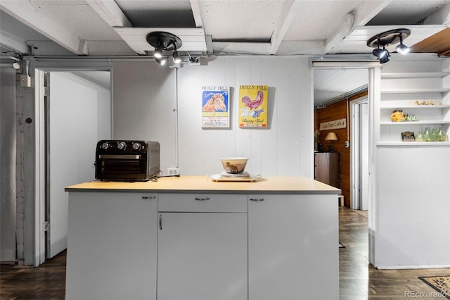 kitchen with dark wood-type flooring and wood walls