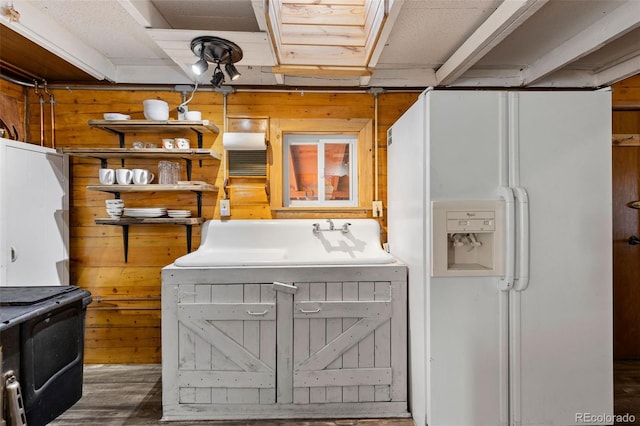 clothes washing area featuring dark hardwood / wood-style flooring and wooden walls