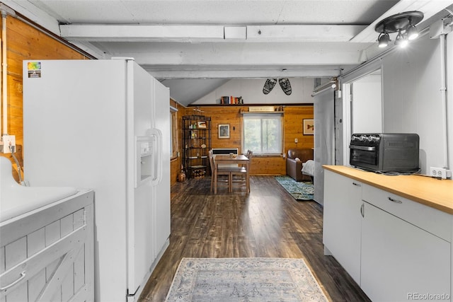 kitchen with vaulted ceiling with beams, white refrigerator with ice dispenser, white cabinetry, dark hardwood / wood-style floors, and wooden walls