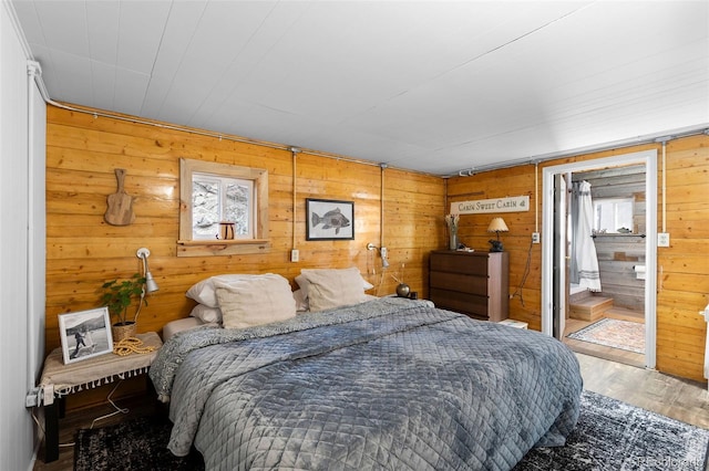 bedroom featuring wood walls and hardwood / wood-style flooring