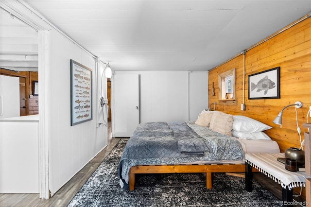 bedroom featuring wood walls and dark hardwood / wood-style floors