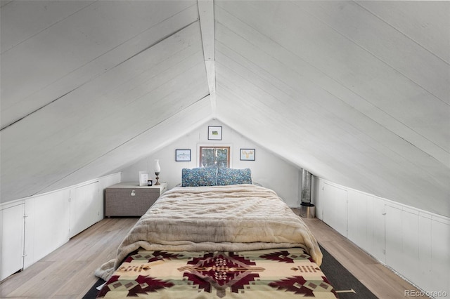 bedroom featuring light wood-type flooring and vaulted ceiling