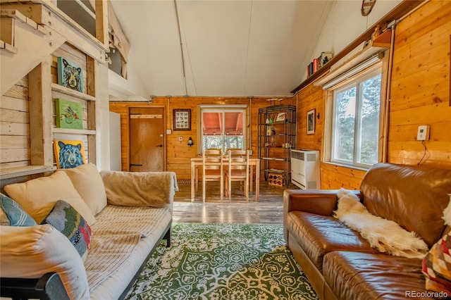 living room with wood walls, high vaulted ceiling, and hardwood / wood-style floors