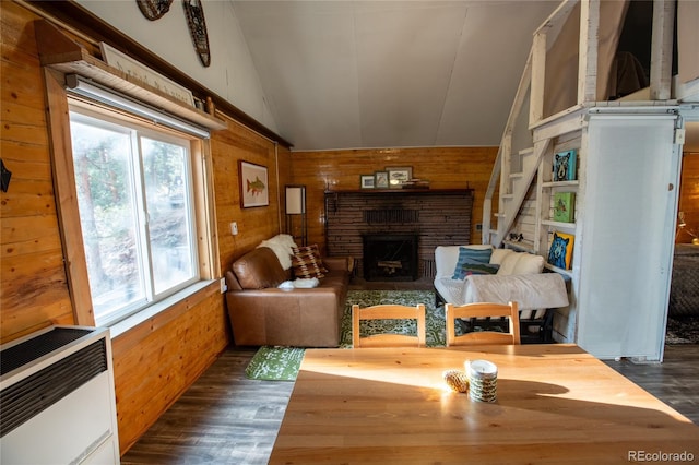 living room featuring a stone fireplace, lofted ceiling, dark wood-type flooring, wood walls, and heating unit