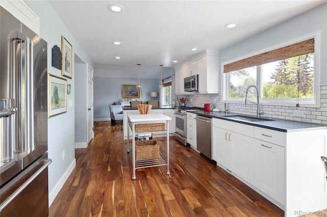 10886 E Berry Ave, Englewood, CO 80111 - kitchen featuring stainless steel appliances, a sink, decorative backsplash, baseboards, and recessed lighting