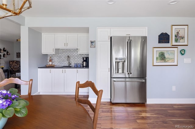 10886 E Berry Ave, Englewood, CO 80111 - kitchen featuring high quality fridge, dark countertops, white cabinetry, decorative backsplash, and recessed lighting