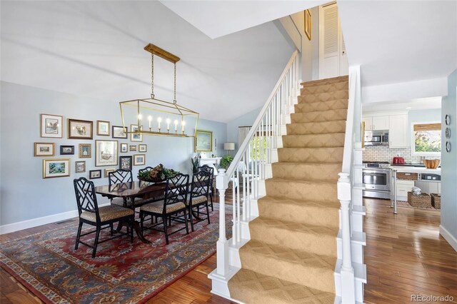 10886 E Berry Ave, Englewood, CO 80111 - dining room featuring stairs, dark wood-style floors, and baseboards