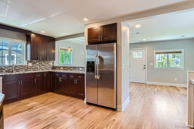 1733 S Gilpin St, Denver, CO 80210 - kitchen featuring stainless steel fridge, light wood-type flooring, dark brown cabinetry, tasteful backsplash, and recessed lighting