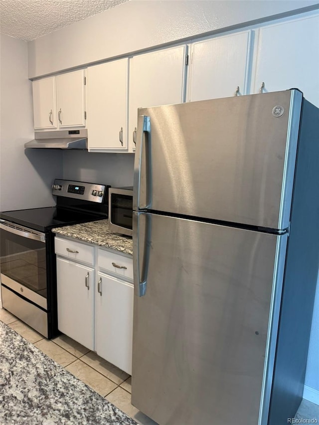 kitchen featuring appliances with stainless steel finishes, under cabinet range hood, white cabinetry, a textured ceiling, and light tile patterned flooring