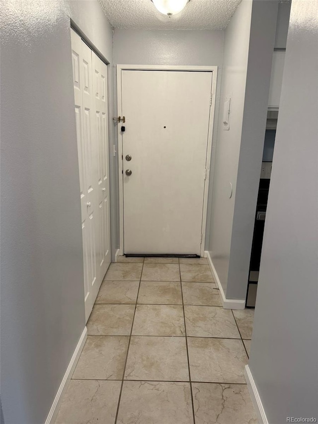 entryway featuring baseboards and a textured ceiling