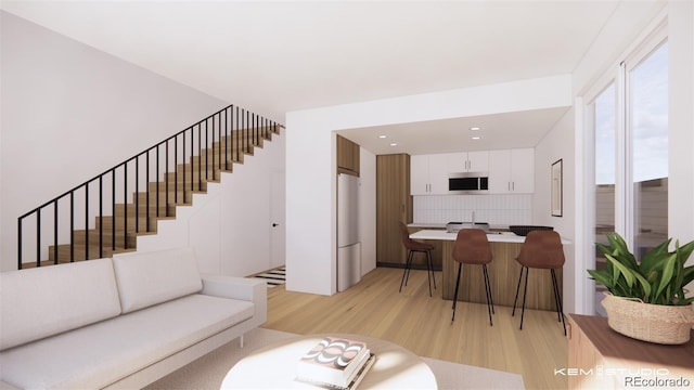 living area featuring light wood finished floors, stairs, and recessed lighting